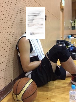 急に決まった練習後、体育館の壁にもたれて休憩するバスケットボール練習後の様子